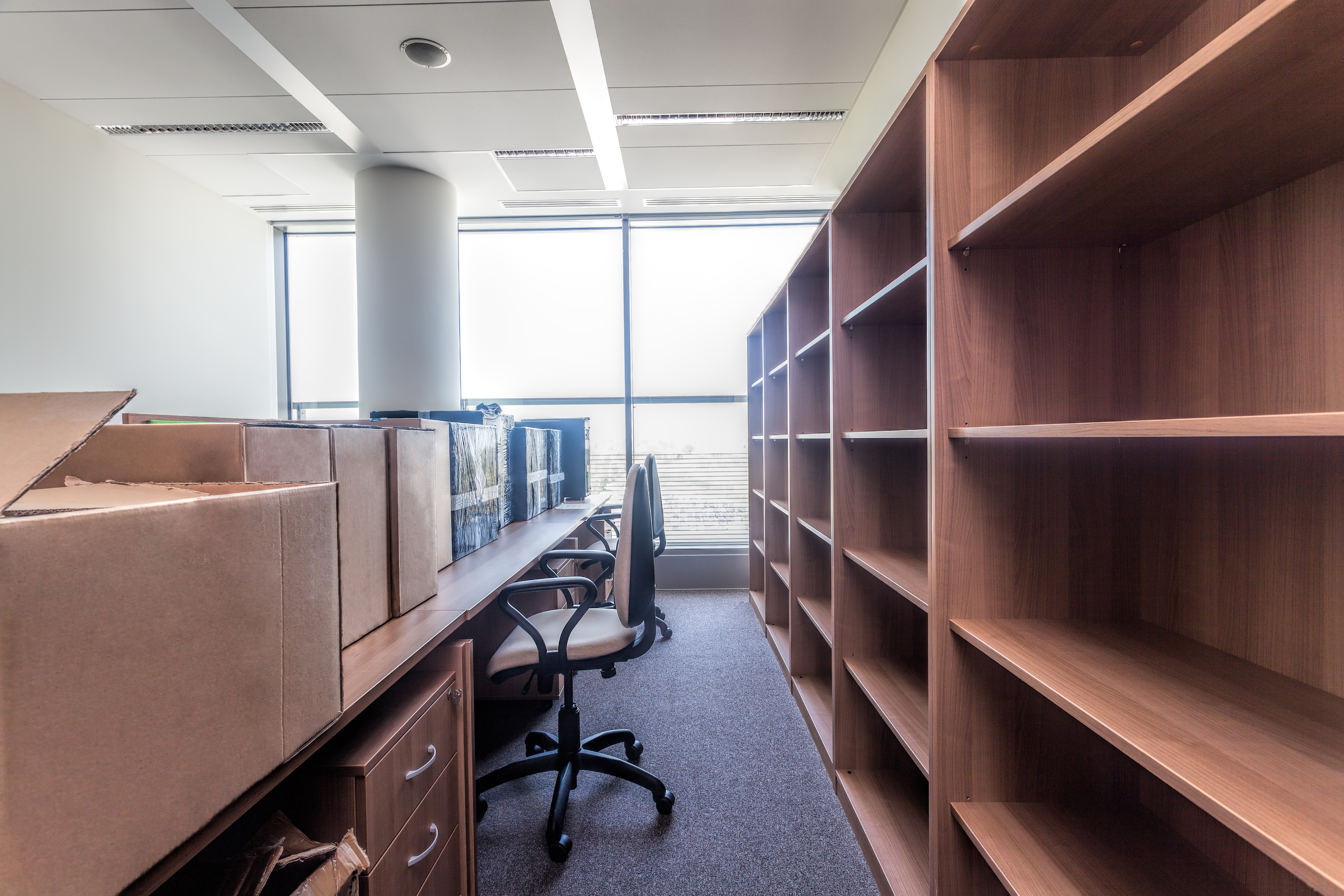 Leeres Büro mit Regalen, Schreibtischen und Umzugskartons – Symbol für professionelle Büroauflösung und Entrümpelung.