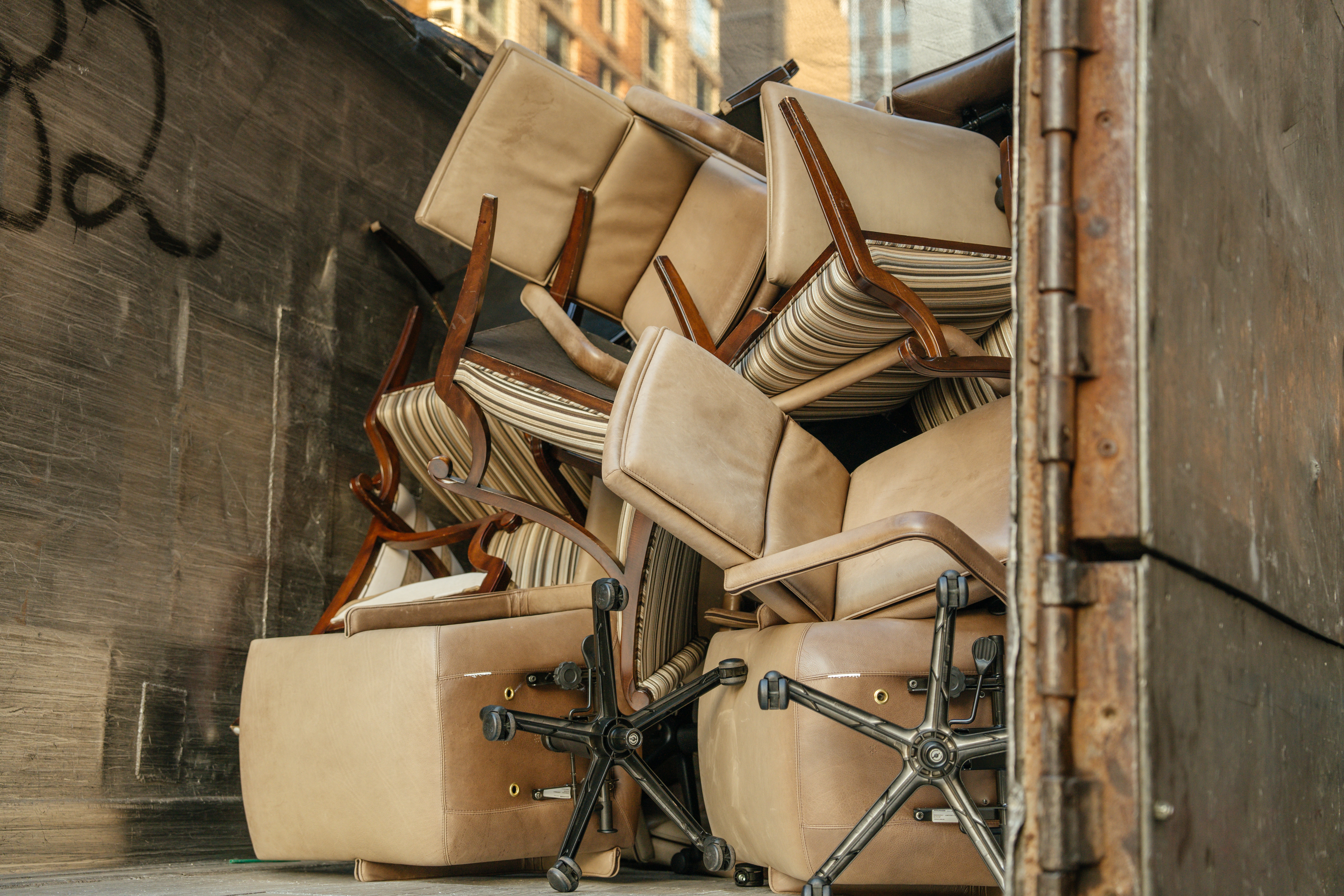 Alte Bürostühle und Möbel in einem Container – Symbol für Geschäftsauflösung, Büroentrümpelung und fachgerechte Entsorgung.